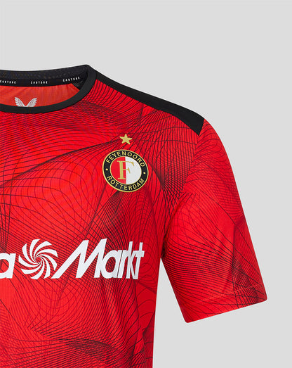 Chest view of Feyenoord home shirt showing crest on left chest and Castore logo on right on red patterned fabric.
