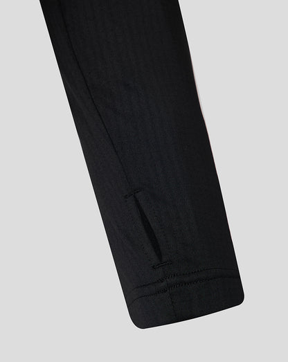 Close-up of a black shirt arm on a light gray background