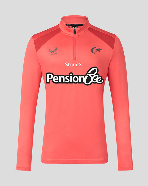 A coral pink long-sleeve athletic quarter-zip pullover with dark red shoulder panels and sponsor logos on the chest, including 'Pension Bee' and 'StoneX', shown against a solid gray background.