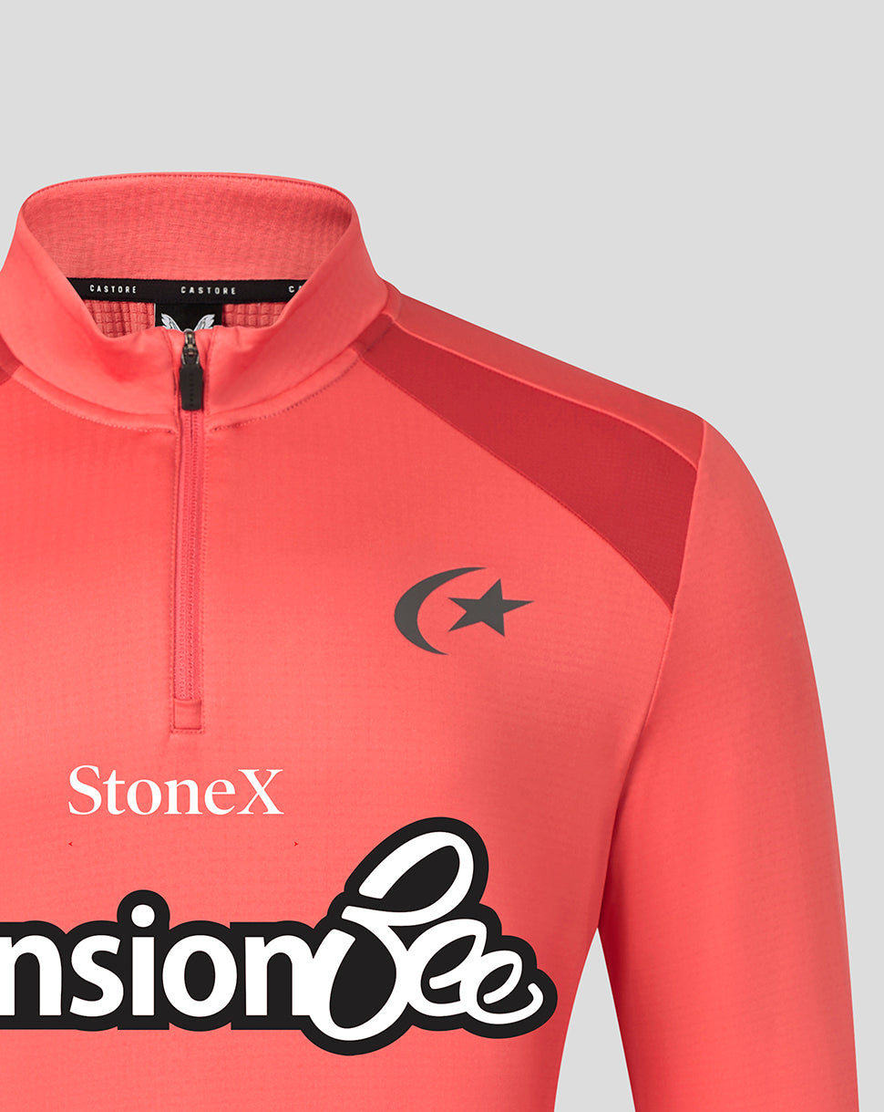 A close-up of a coral pink athletic quarter-zip pullover with a mock neck, featuring a black crescent and star logo on the chest, the brand name 'StoneX' printed in white, and a large black and white graphic at the bottom.