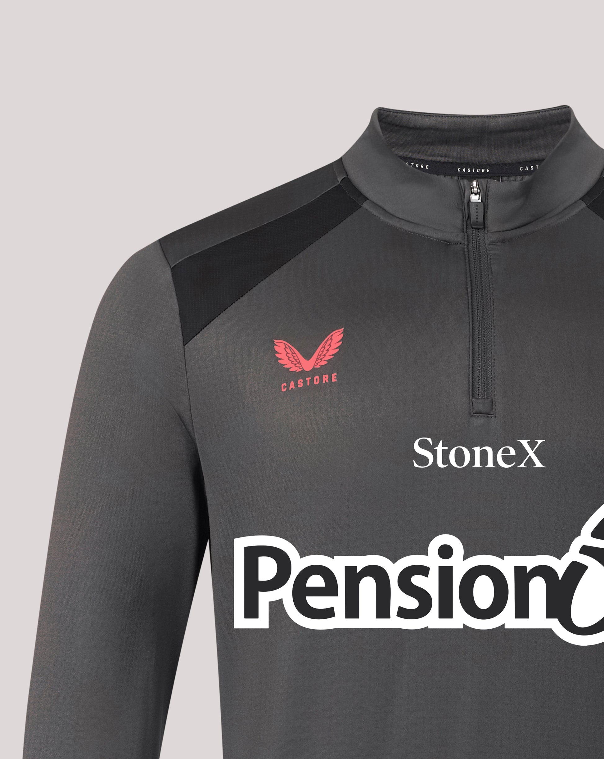 A close-up of a dark gray long-sleeve athletic quarter-zip pullover with black shoulder panels. The chest features a red winged logo with 'CASTORE' underneath, and white sponsor logos 'StoneX' and 'Pension' printed across the front.