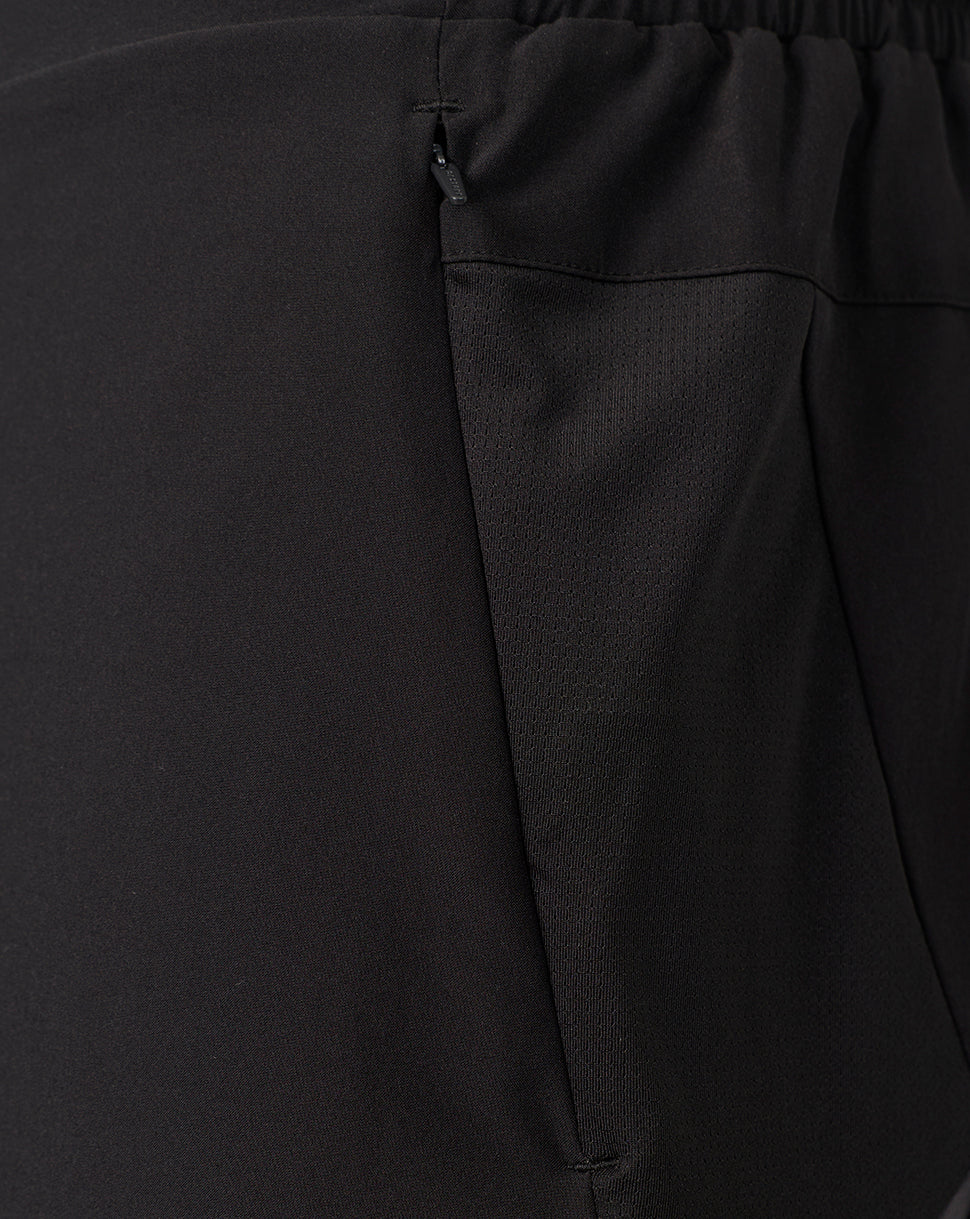 Close-up of black textured fabric with an elastic waistband and a side zipper pocket.