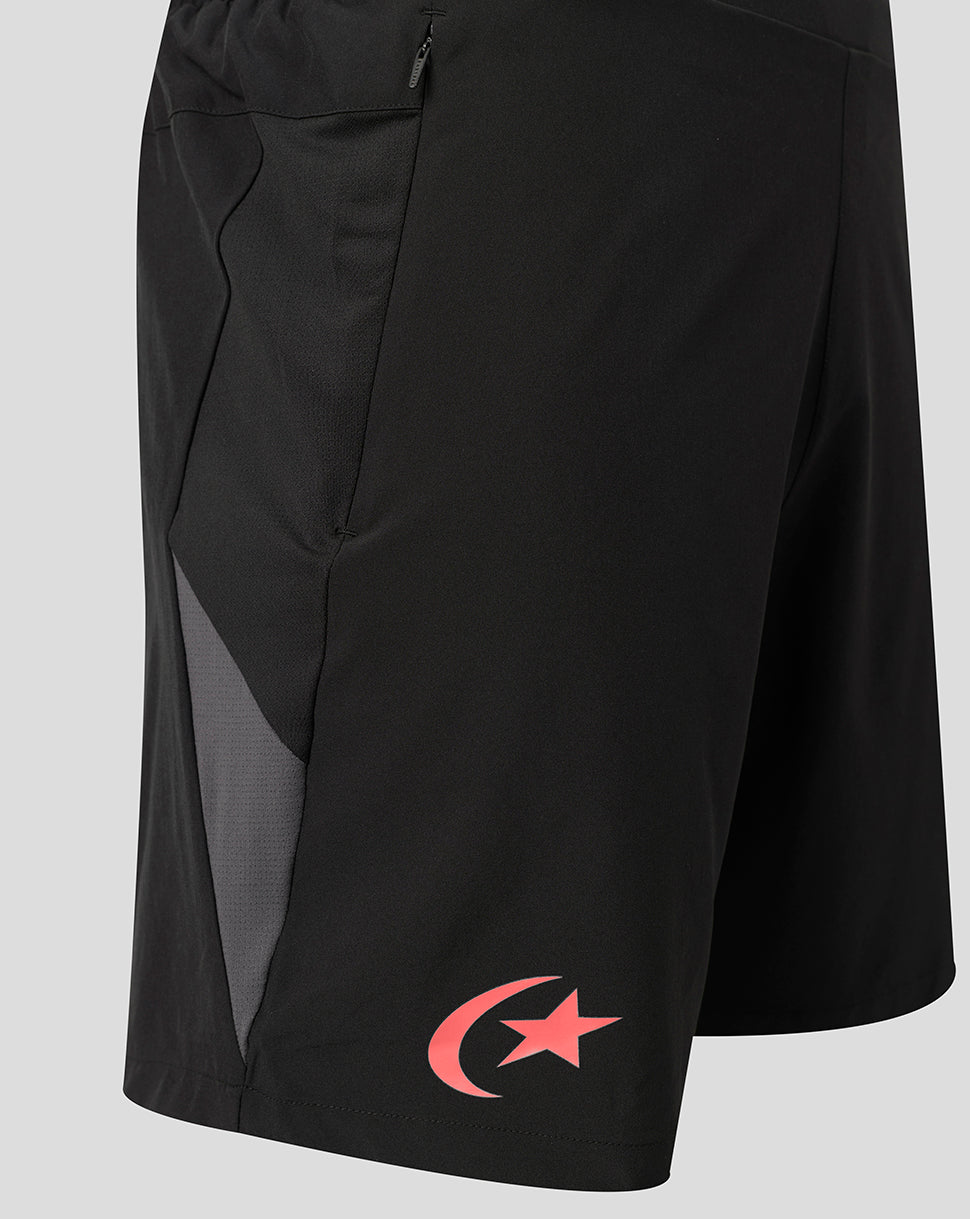 Black athletic shorts with a side zip pocket, a gray mesh side panel, and a red crescent and star logo near the hem, shown against a light gray background.