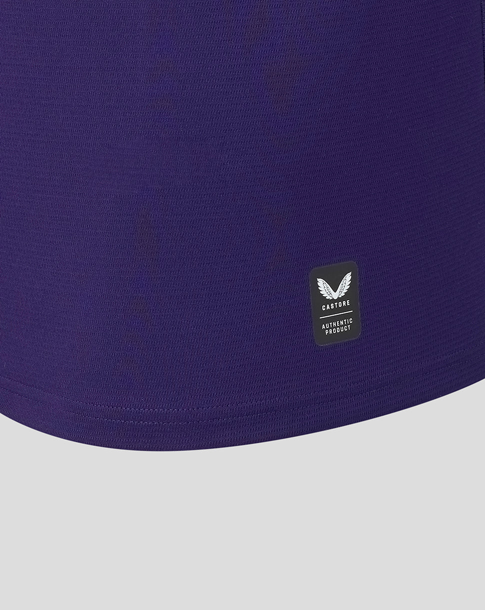 Close-up of a purple garment with a brand logo on a light gray background
