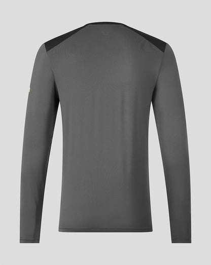 A dark gray long-sleeve athletic shirt shown from the back, featuring dark shoulder panels and a subtle tonal logo on the upper back, set against a solid light gray background.