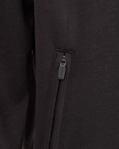 Close-up of a dark charcoal gray zippered pocket on a textured knit garment.
