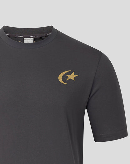 A close-up of a dark gray crewneck t-shirt featuring a gold crescent moon and star logo on the left chest, displayed on a neutral gray background.