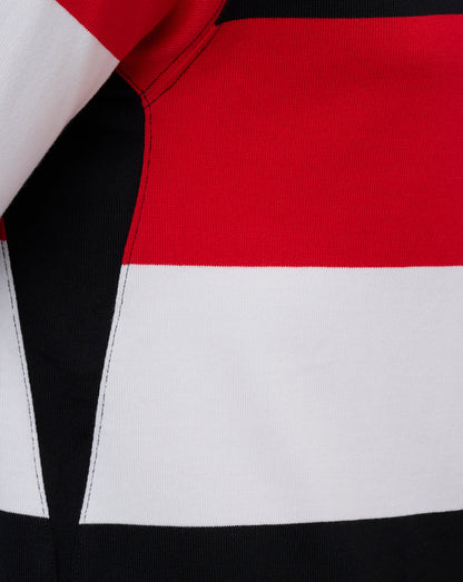 Close-up of a color-blocked knit garment showing red, white, and black horizontal panels with visible stitching.