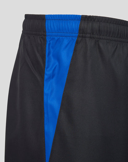 Close-up of athletic shorts in black with a bright blue vertical side panel and matching blue elastic waistband, shown against a light gray background.