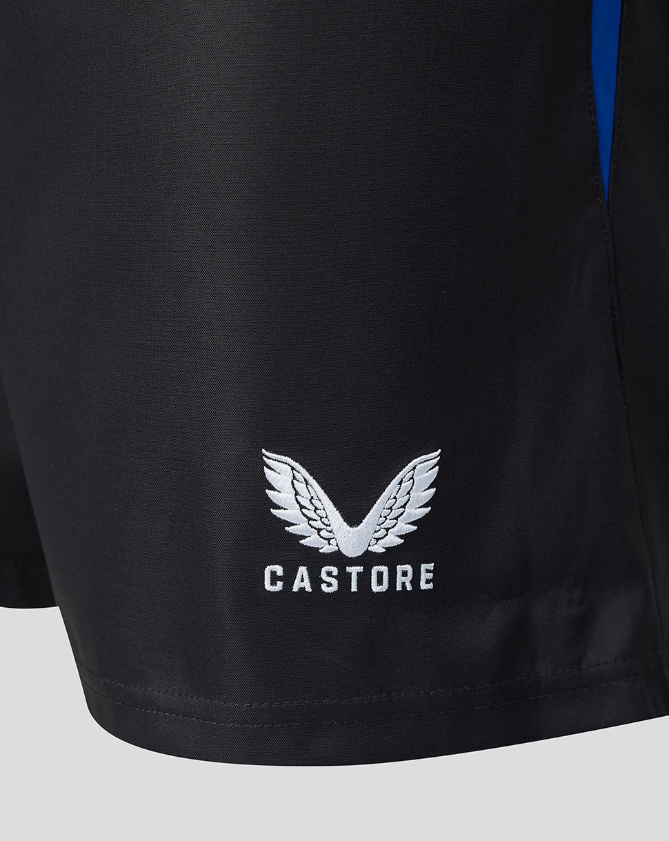 Close-up of black athletic shorts with a white Castore wing logo and brand name printed on the lower left leg, plus a small blue side panel detail.