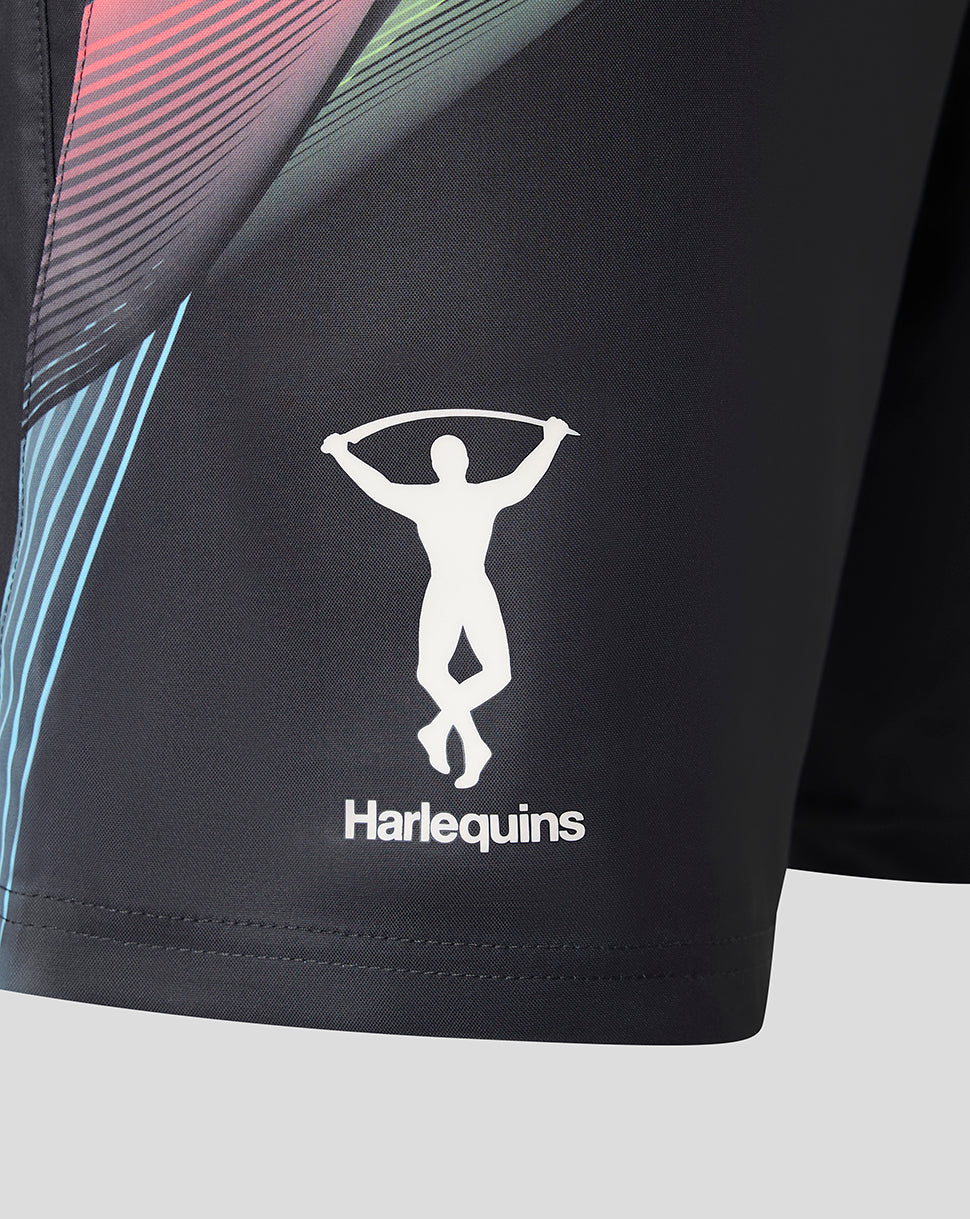 Close-up of black athletic shorts with a white Harlequins logo and a multicolor diagonal stripe pattern on the side, shown against a light gray background.