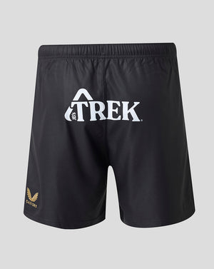 Black athletic shorts with a white Trek logo on the front and a small gold logo on the lower left leg, shown against a light gray background.