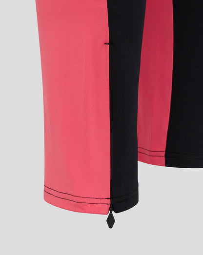 Close-up of pink and black joggers with a zipper on a light gray background