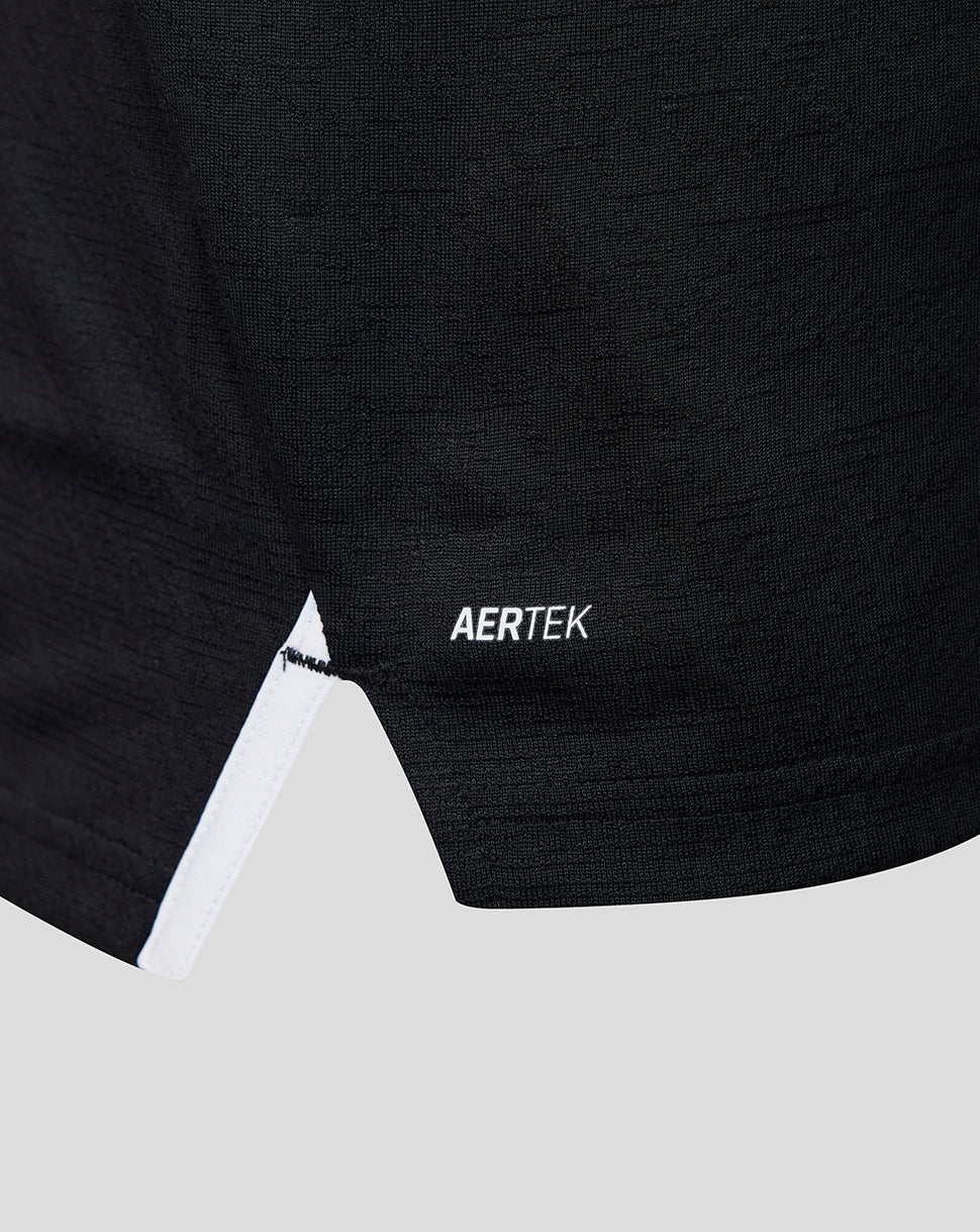 Close-up of the lower front of a black athletic shirt showing the AERTEK label and white trim at the hem