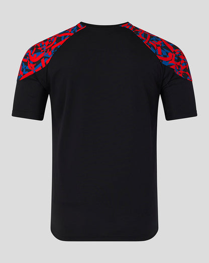 A black short-sleeve athletic t-shirt with a red and blue abstract patterned shoulder yoke, shown from the back on a light gray background.