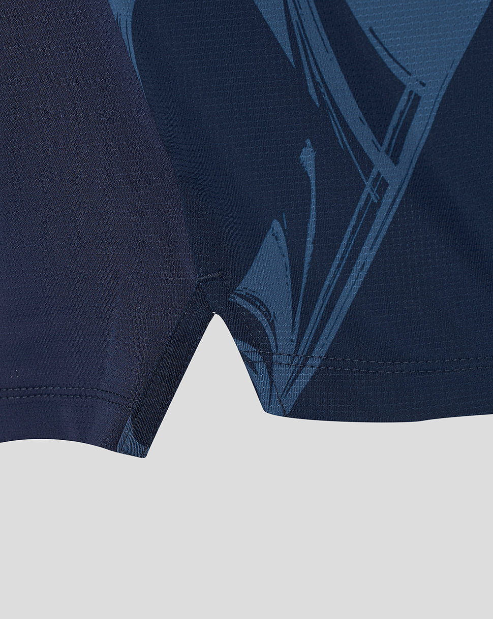 Close-up of a dark navy athletic garment showing the fabric texture and a tonal blue graphic pattern.