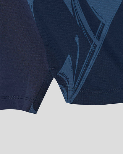 Close-up of a dark navy athletic garment showing the fabric texture and a tonal blue graphic pattern.