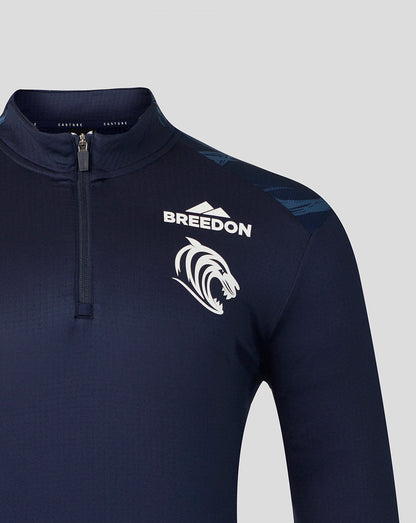 A close-up of a dark navy long-sleeve athletic quarter-zip pullover with a white 'BREEDON' text logo and a white stylized animal head graphic on the left chest, set against a solid light gray background.