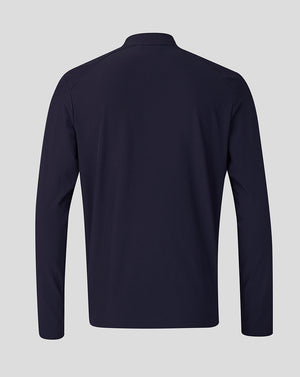 A dark navy long-sleeve athletic top shown from the back, featuring a high collar and a clean, flat silhouette against a solid light gray background.