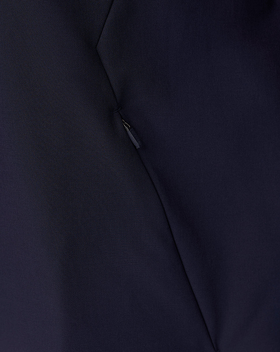 Close-up of a dark navy blue fabric surface with a small metallic zipper pull and visible seam lines.