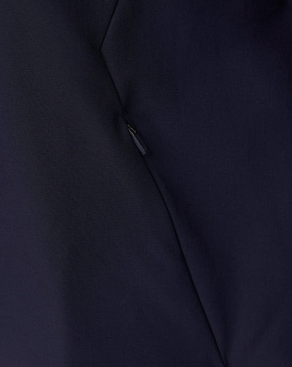 Close-up of a dark navy blue fabric surface with a small metallic zipper pull and visible seam lines.