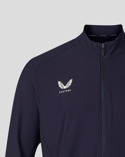 A close-up of a navy blue zip-up jacket with a white Castore wing logo and brand name printed on the left chest, set against a solid light gray background.