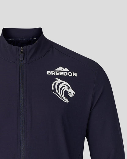 A close-up of a dark navy athletic jacket featuring a white 'BREEDON' text logo and a white stylized lion head graphic on the left chest, set against a solid light gray background.