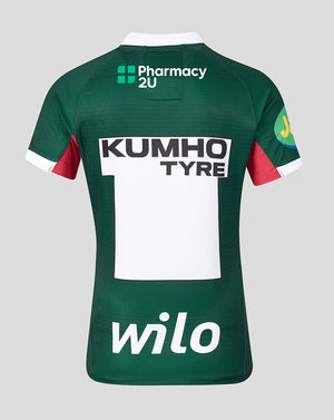 Back view of a dark green short-sleeve sports jersey with white and red accents, featuring sponsor logos including Pharmacy 2U, Kumho Tyre, and wilO on a light gray background.