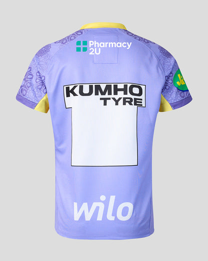 The back of a light purple rugby jersey with yellow accents, featuring sponsor logos including Wilo, Pharmacy 2U, and Kumho Tyre, on a solid gray background.