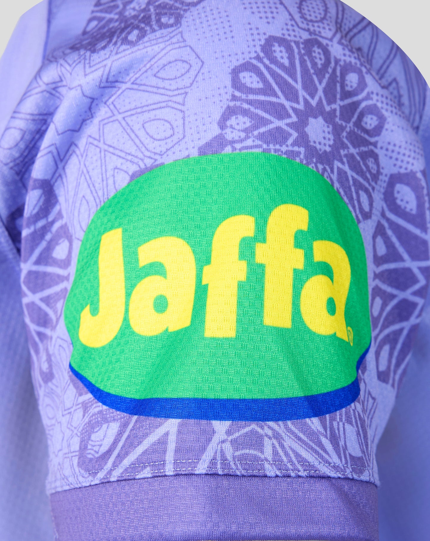 Close-up of a purple patterned athletic jersey with a large green Jaffa logo patch and yellow Jaffa lettering on the front.