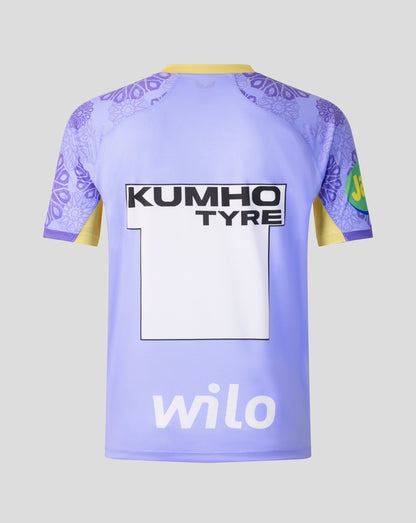 The back of a light purple soccer jersey with yellow collar and sleeve accents, featuring 'KUMHO TYRE' and 'wilo' sponsor logos, set against a solid gray background.