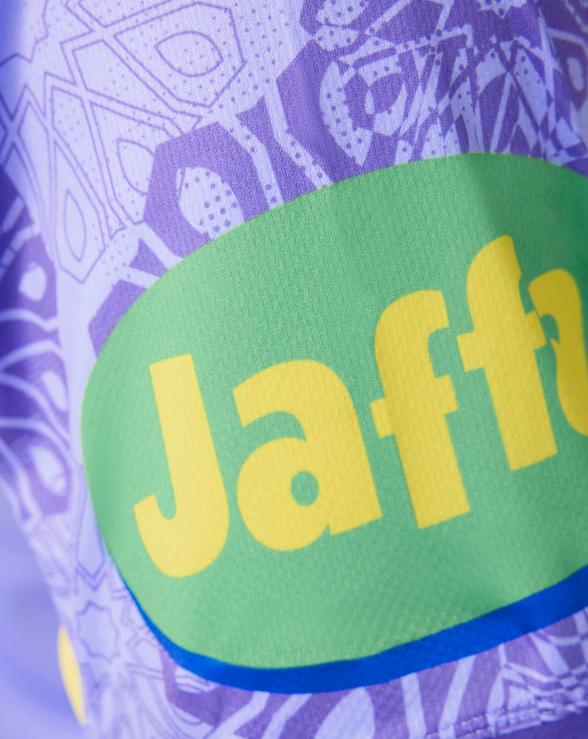 Close-up of a purple patterned athletic jersey with a large green Jaffa logo patch and yellow Jaffa branding.