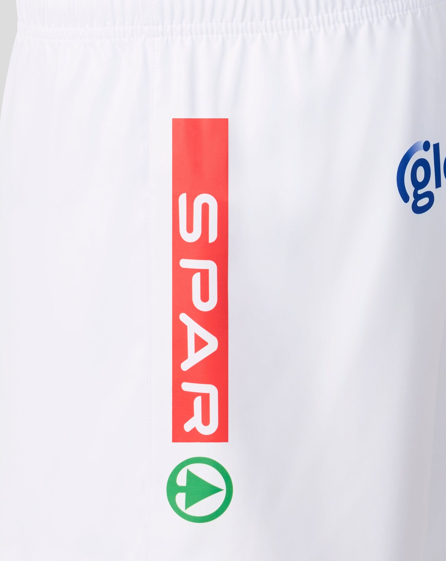 White athletic shorts featuring a vertical red sponsor block with the word 'SPAR' in white, a green circular play-button logo below it, and part of a blue circular logo on the right side.