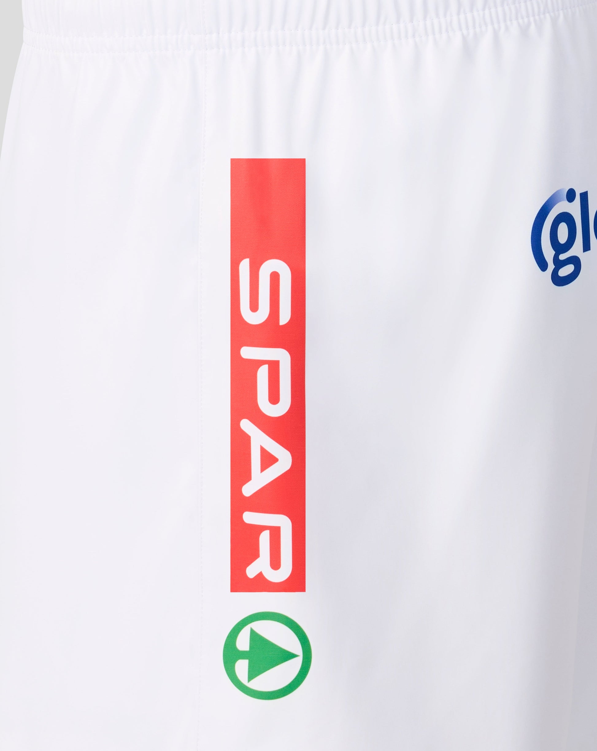 White athletic shorts featuring a vertical red sponsor block with the word 'SPAR' in white, a green circular play-button logo below it, and part of a blue circular logo on the right side.