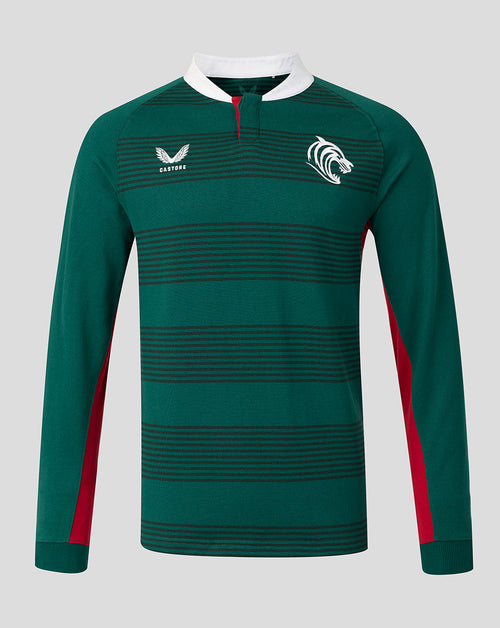 A dark green long-sleeve rugby jersey with horizontal dark stripes, a white collar, red side panels, and white logos on the chest, displayed on a neutral gray background.