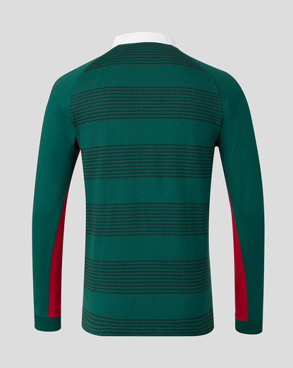 A long-sleeve knit top shown from the back, featuring horizontal dark green stripes on a dark green base with red side panels on the sleeves, displayed on a white mannequin torso against a light gray background.