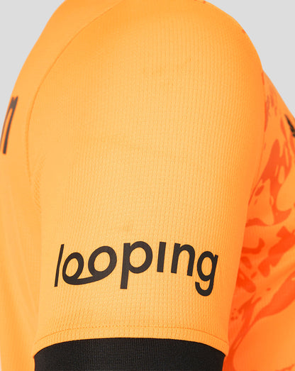Close-up of bright orange FC Twente goalkeeper shirt sleeve with bold black sponsor text.