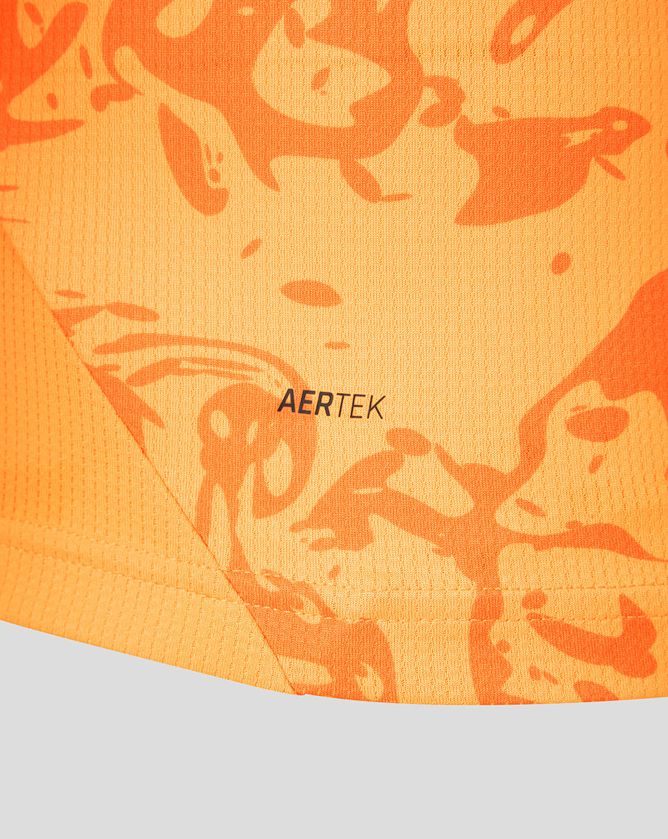 Close-up of orange textured fabric with a camo pattern and AERTEK branding on the FC Twente shirt.