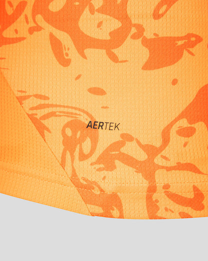 Close-up of orange textured fabric with a camo pattern and AERTEK branding on the FC Twente shirt.