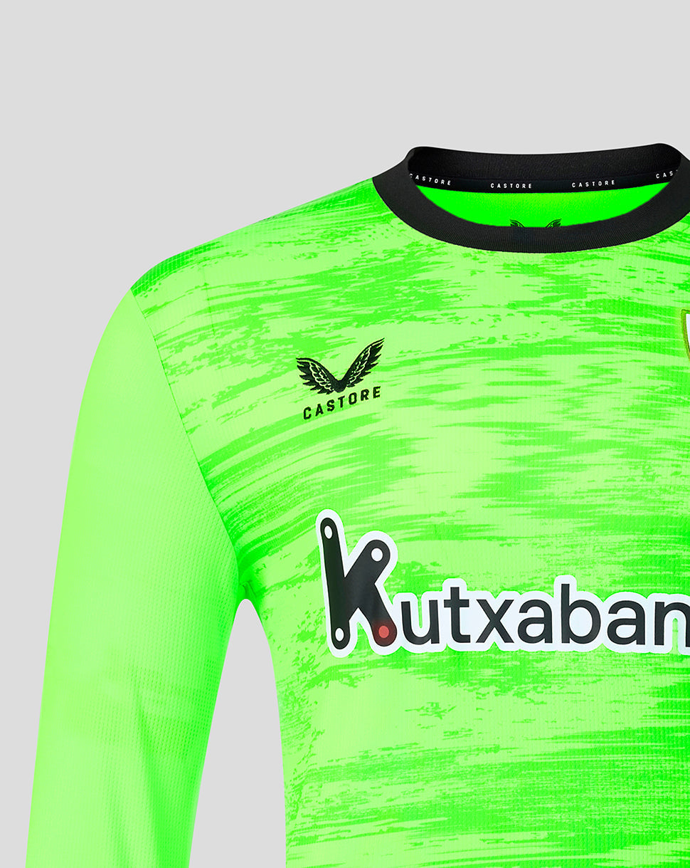 Close up of the neon green goalkeeper shirt front showing Athletic Club crest on the left chest and Kutxabank sponsor.