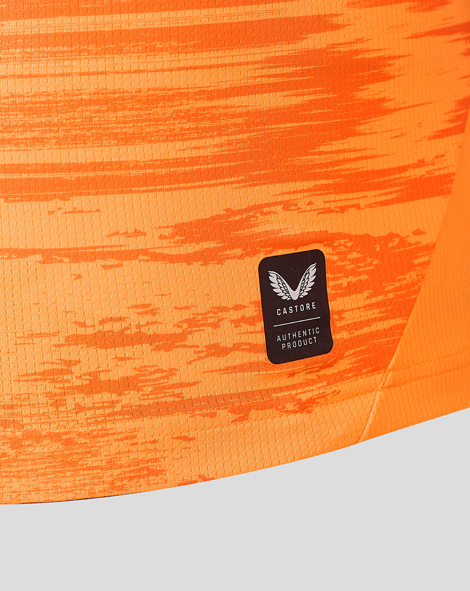 Close-up of orange goalkeeper shirt fabric with Castore authentic product patch