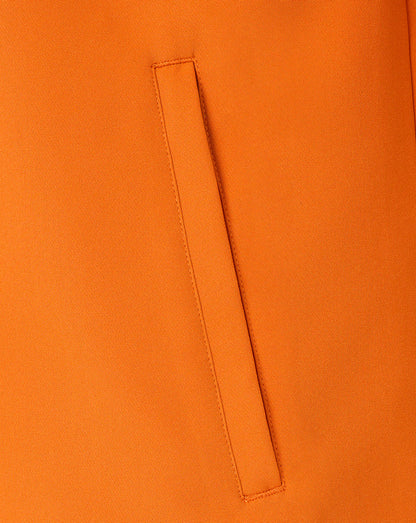 Close-up of a bright orange fabric surface with a vertical stitched welt pocket detail.
