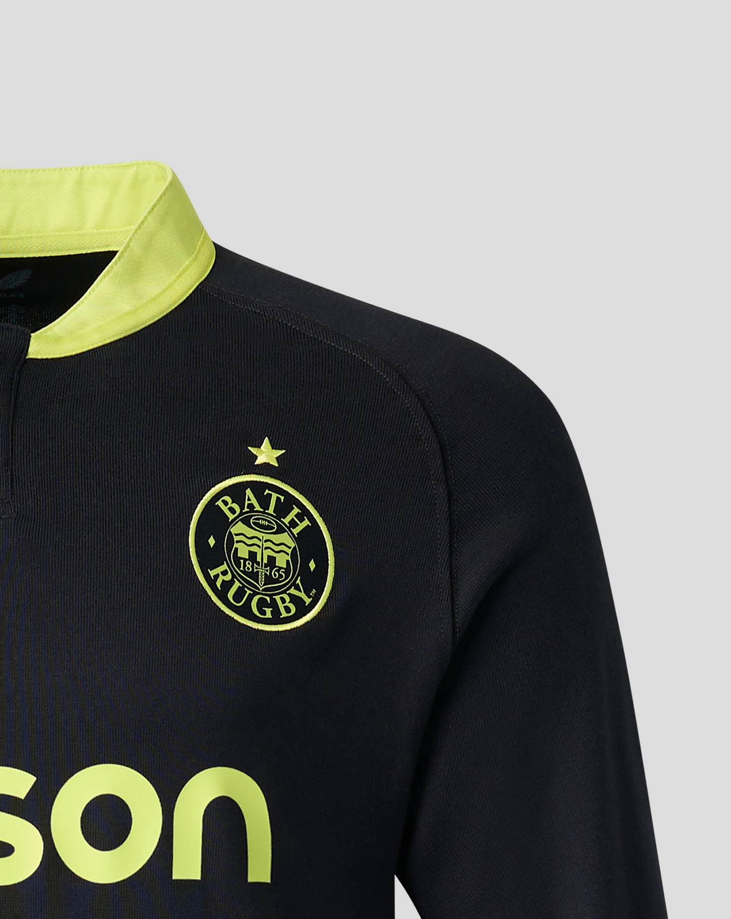 Close-up of a Bath Rugby athletic top in black with a bright yellow collar and yellow logo details, including the Bath Rugby crest and partial sponsor text.