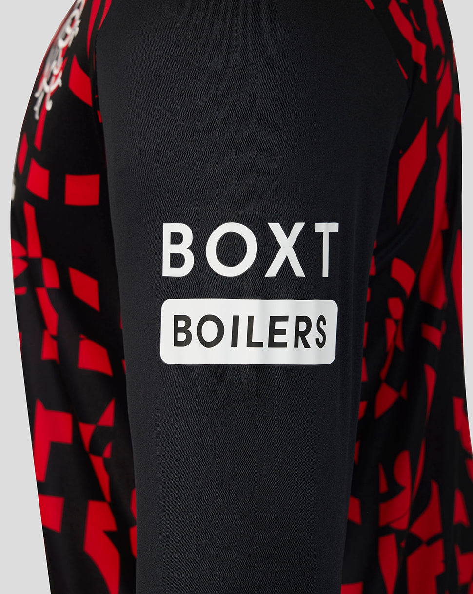 Close-up of a long-sleeve top with a black body, red geometric pattern on the sleeves, and a white BOXT BOILERS logo printed on the chest.