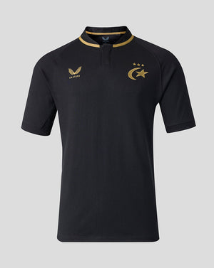 A black short-sleeve polo shirt with gold trim on the collar and gold printed logos on the chest, displayed against a solid gray background.