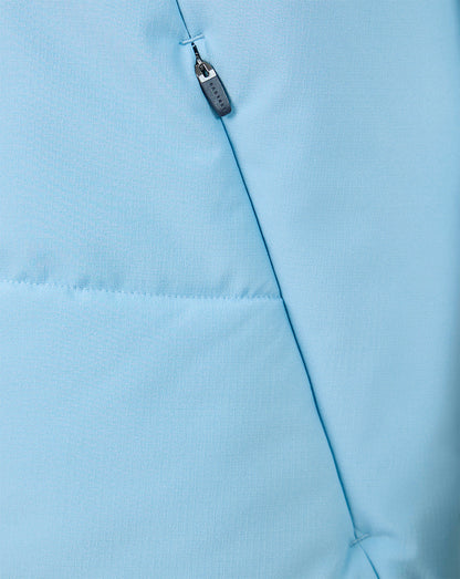 Close-up of light blue fabric showing a vertical zip pocket and diagonal seam on the training gilet.
