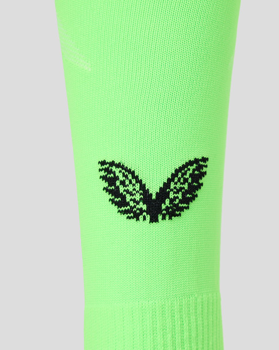 A close-up of a bright neon green athletic sock featuring a black knit Castore logo on the calf, set against a solid light gray background.