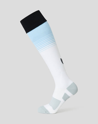 A single knee-high athletic sock shown on a ghost mannequin against a light gray background. The sock features a white main body, a light blue band with horizontal stripes near the top, a black ribbed cuff, and light gray textured panels on the heel and toe.
