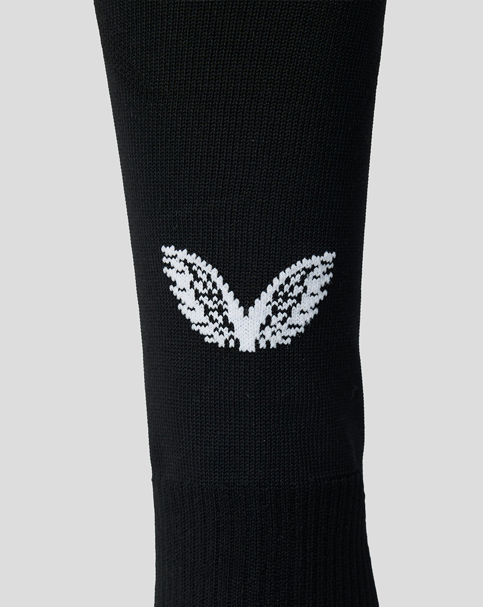 Close-up of white Feyenoord leaf emblem on black sock.