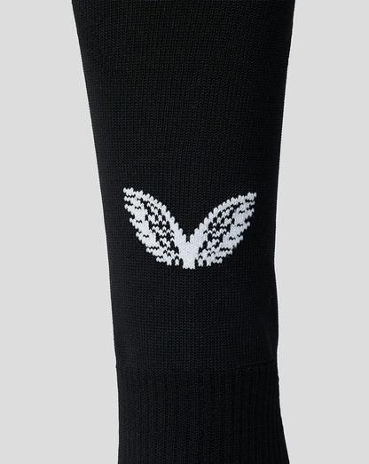 Close-up of white Feyenoord leaf emblem on black sock.